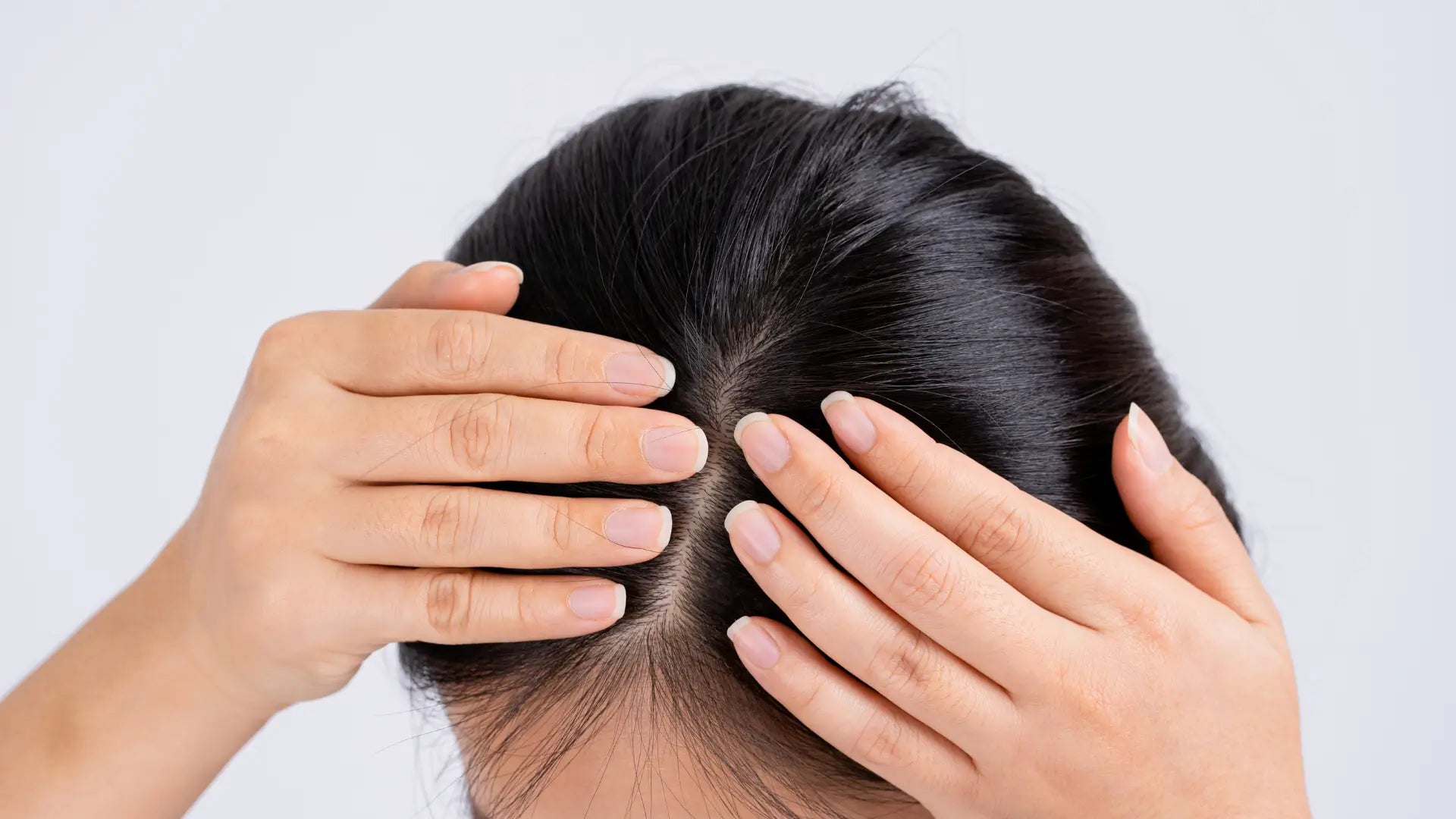 Woman with black hair fingers parting on her scalp