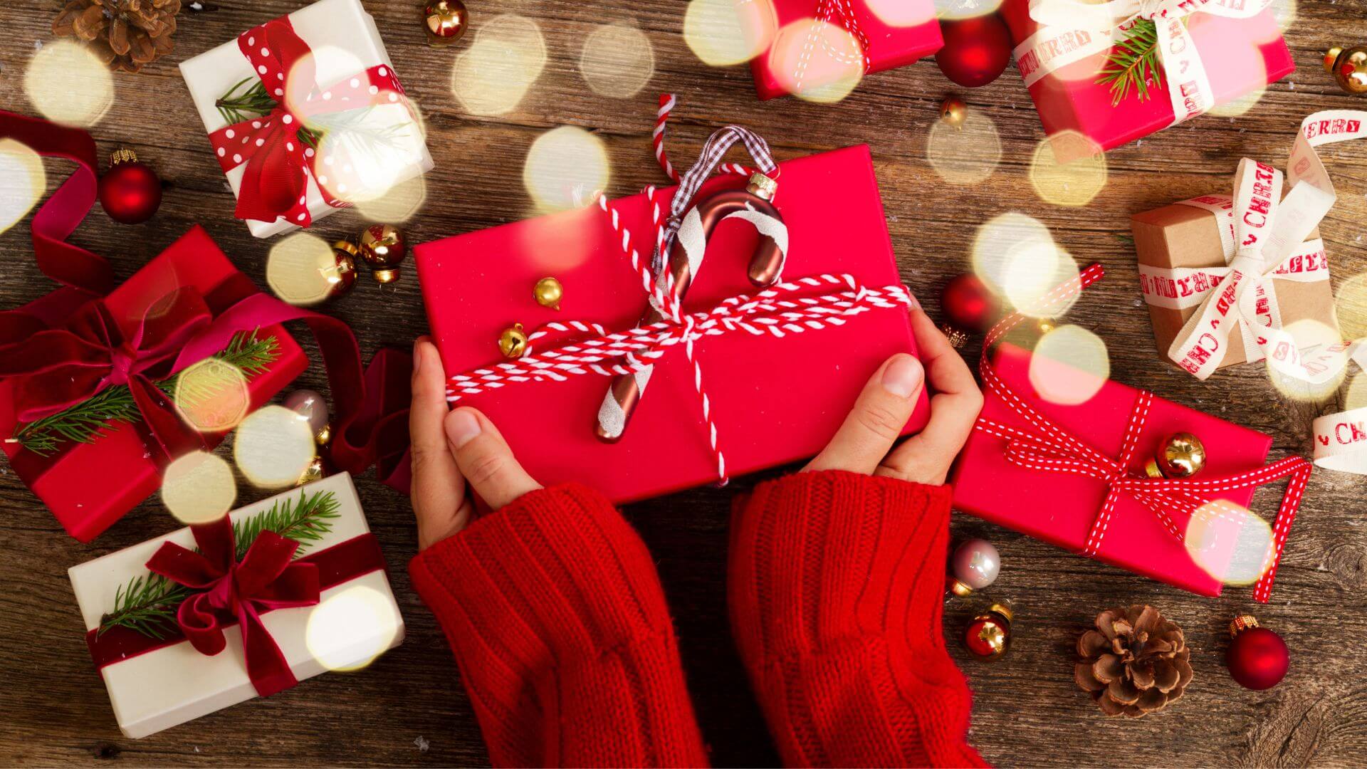 Hands holding Christmas Gifts in Red Wrapping 